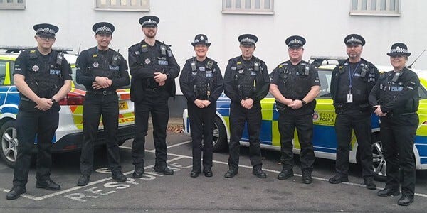 Eight Specials Constables standing in front og two police cars
