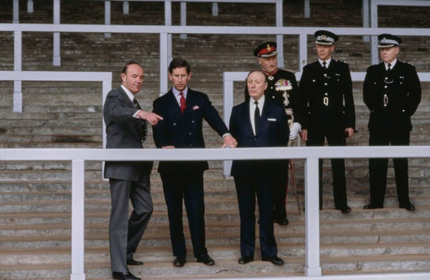 British Royal Charles, Prince of Wales, with Chairman of Liverpool Football Club John Smith and unspecified people standing on The Kop during a visit...