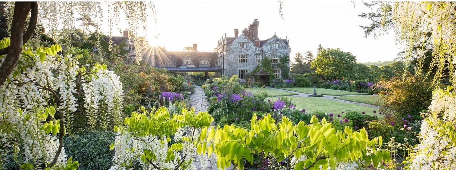 An old country house in a pretty garden with white wisteria