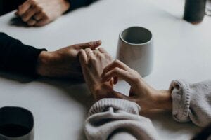 Closeup of the hands of two people holding hands