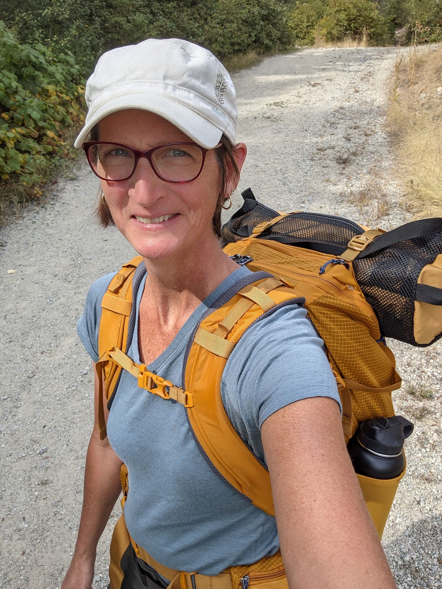 a selfie of me, out on a trail, wearing my yellow backpack