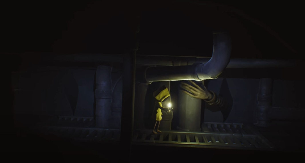 A screenshot from the first Little Nightmares, where one of the arms of The Janitor is reaching into a gap in the wall, searching for Six, who stands nearby, illuminated by the light of her lighter.