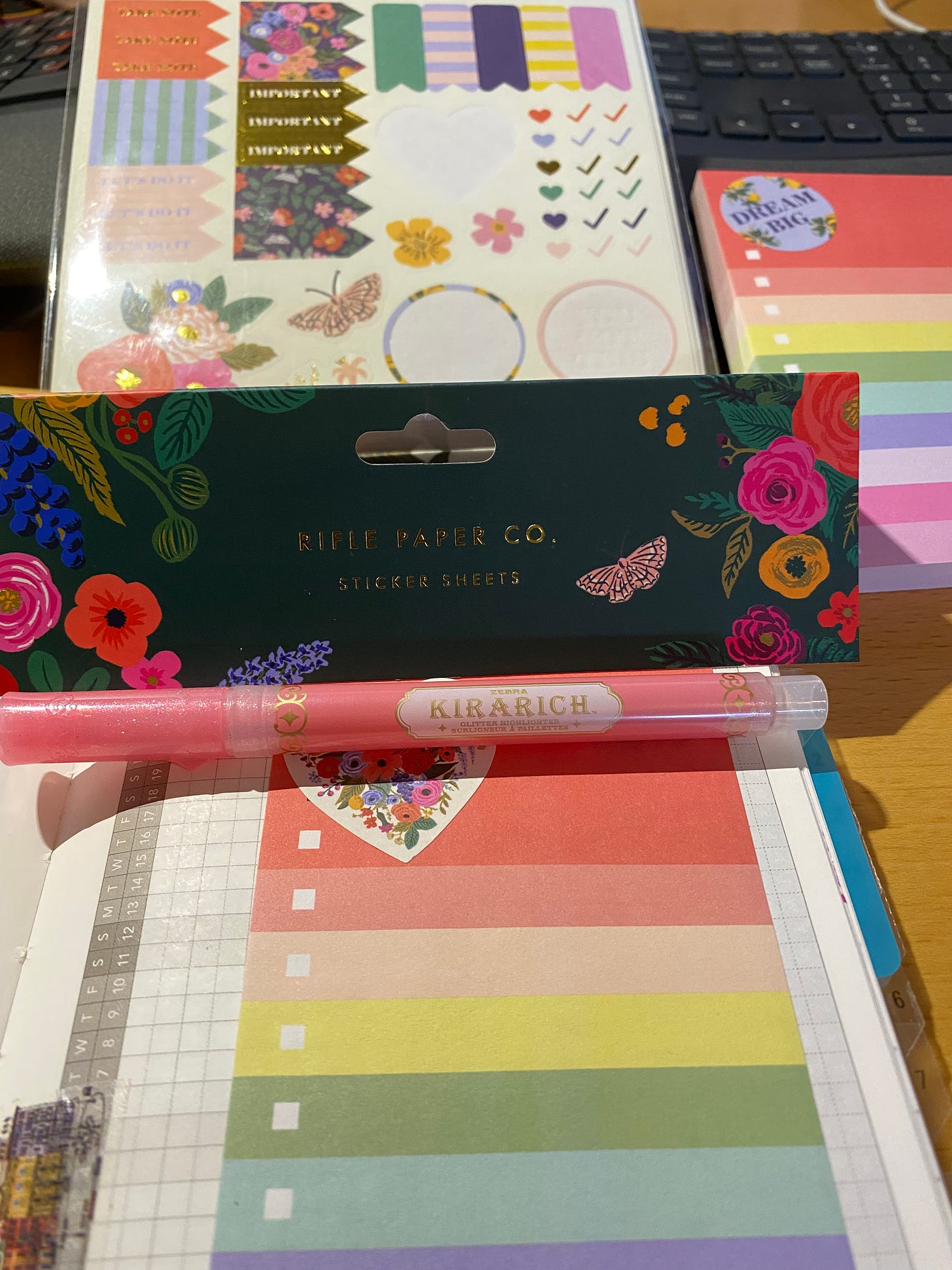 Picture of Rifle Paper planner stickers, Karachi glitter highlighter, and Post-It to-do rainbow notepad.