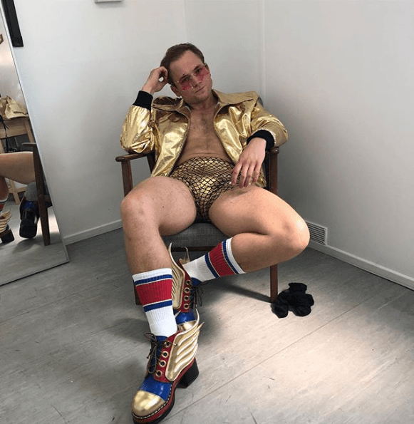 Taron Egarton in tight gold shorts shirtless for Elton John Rocket Man movie.