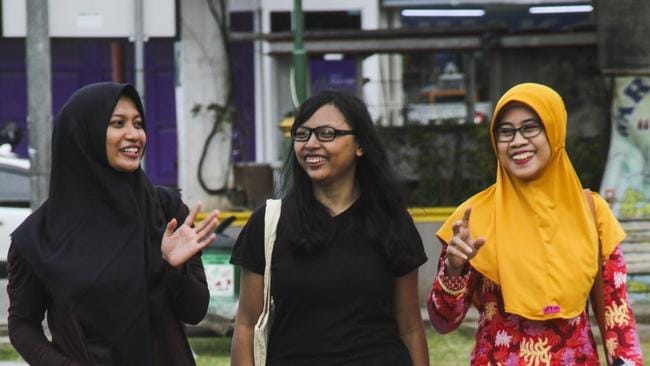 Sri Mulyana, centre, with friends in Batang, where she wears a jilbab to work as a condition of her employment but otherwise chooses not to wear the headscarf, and for this she endures criticism. Picture: Budi Purwanto