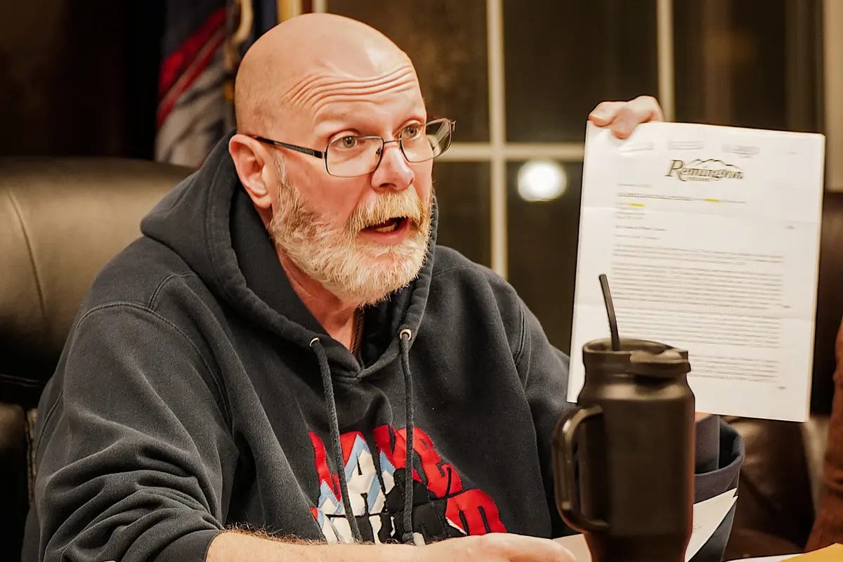  John Stephens, mayor of the village of Ilion, holds up a document from Remington Arms during a village board of trustees meeting in Ilion, N.Y., on Dec. 11, 2023. (Allan Stein/The Epoch Times)