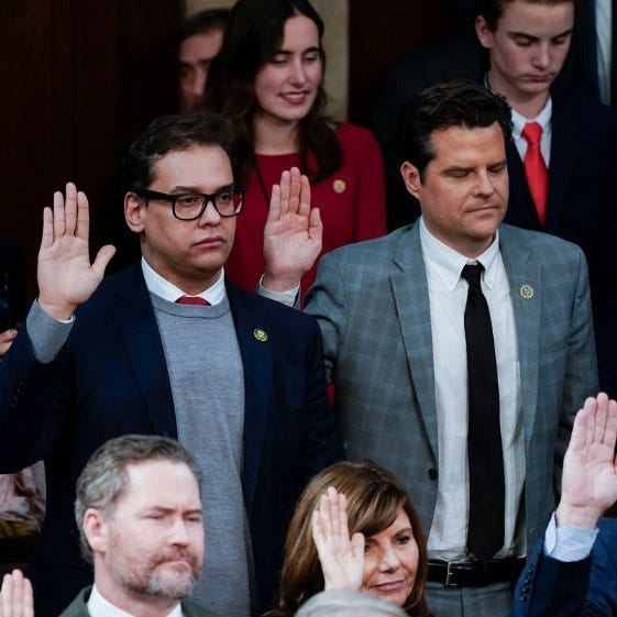 United States Representatives George Santos and Matt Gaetz stand amongst their colleagues with hands raised 