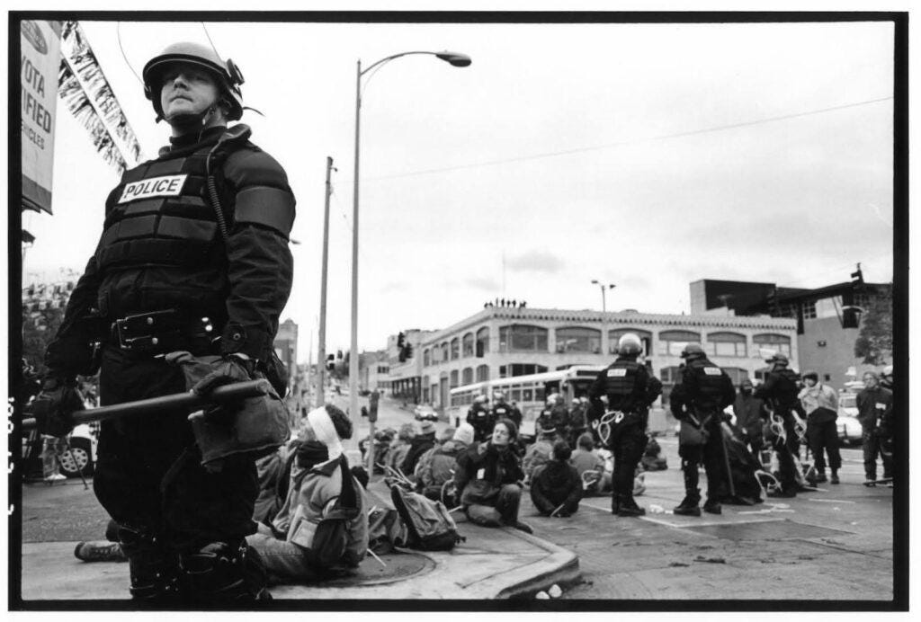 A police officer standing in front of a crowd

Description automatically generated