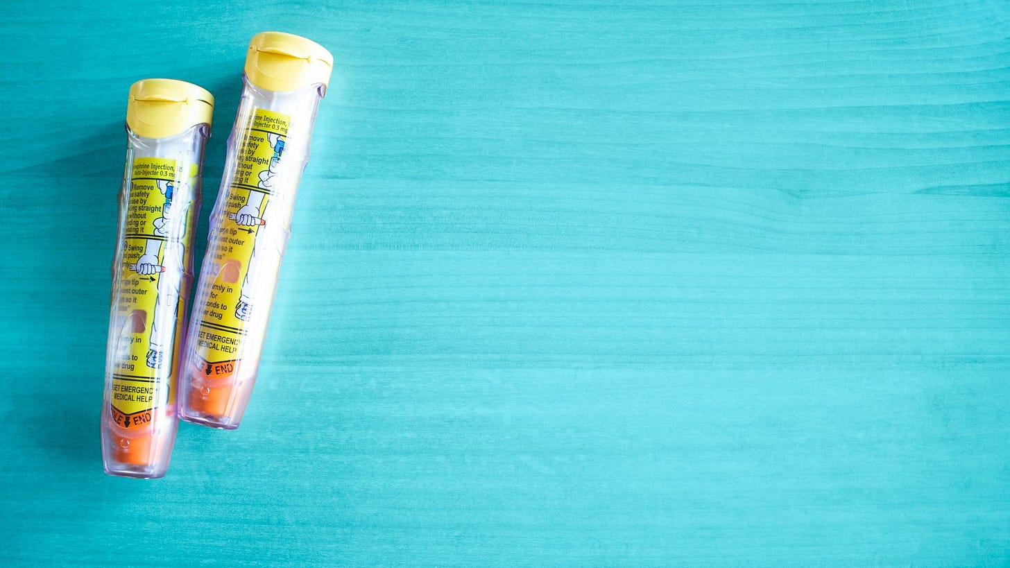 EpiPen autoinjector devices against a turquoise background.