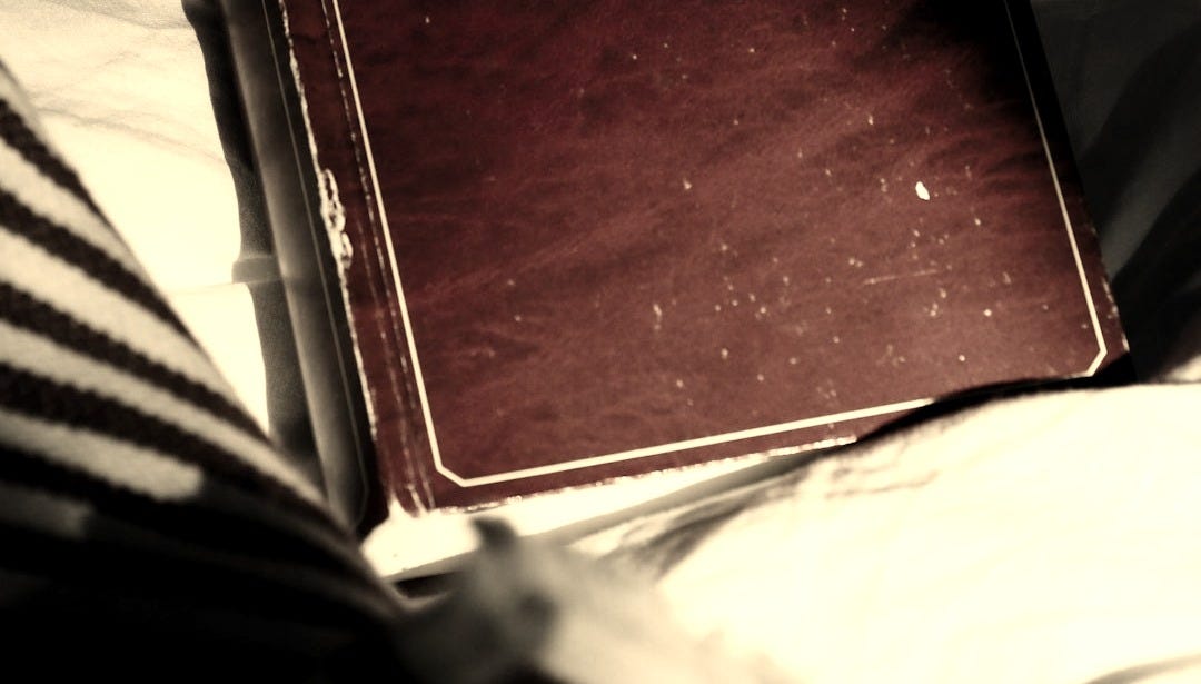 red book on white and black stripe textile