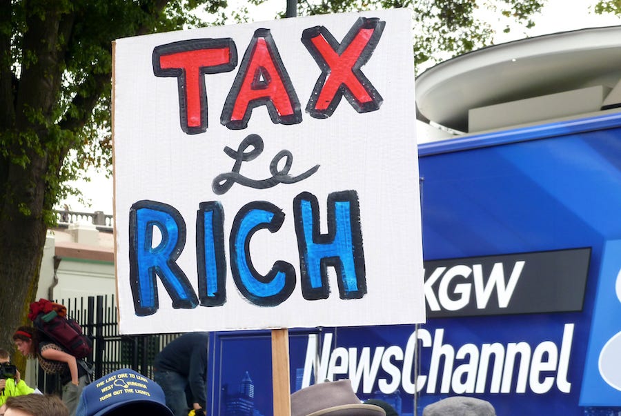 protest sign that says tax le rich