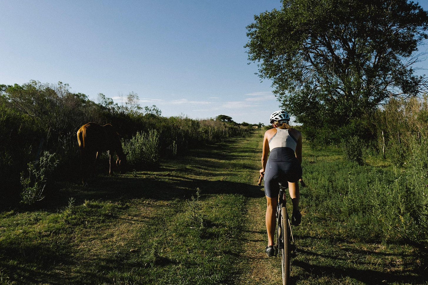 Femme a velo sur un chemin de terre