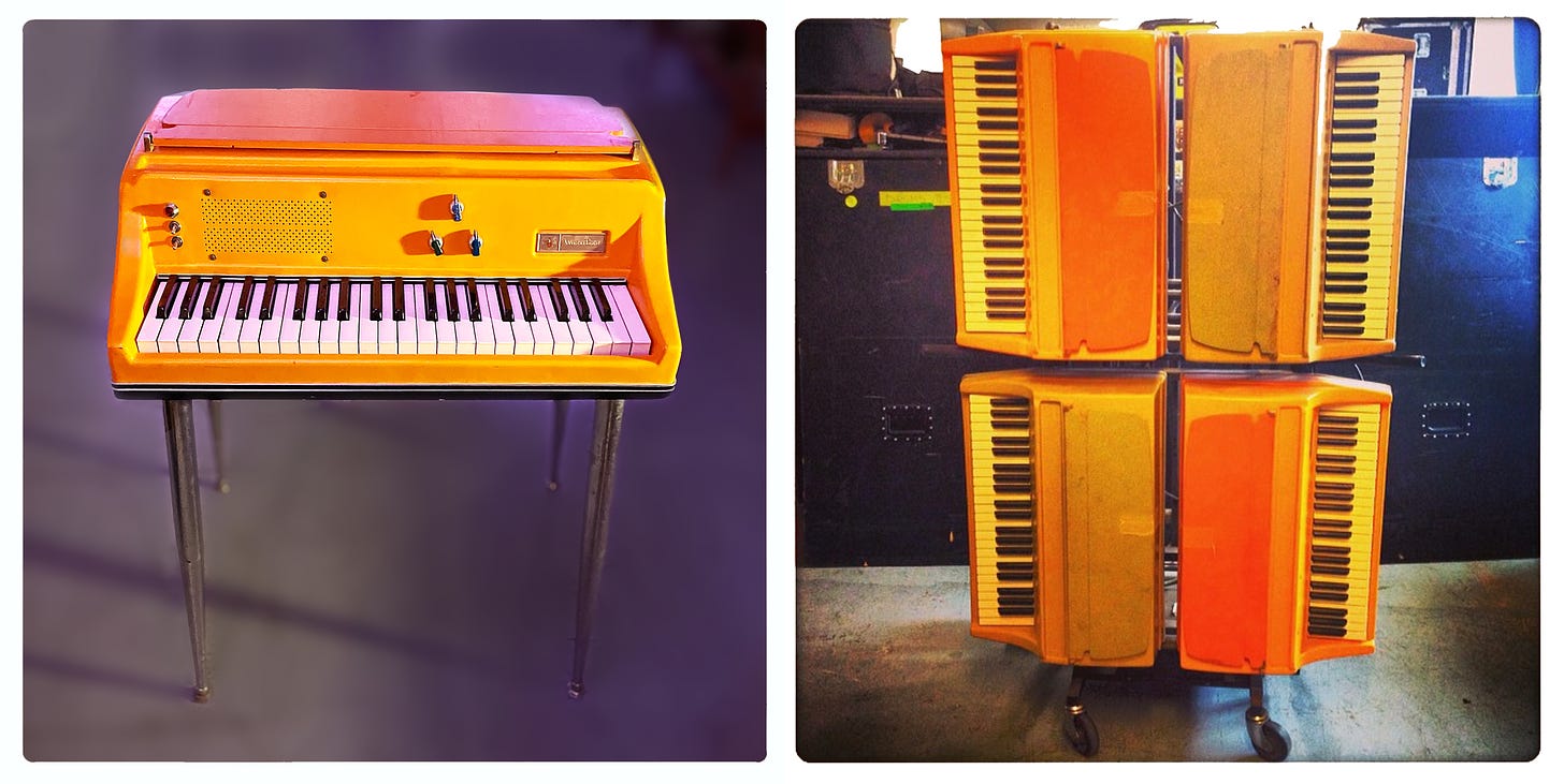 The orange Wurlitzer 106P electric keyboard in standing position and on its Music Learning Module cart.