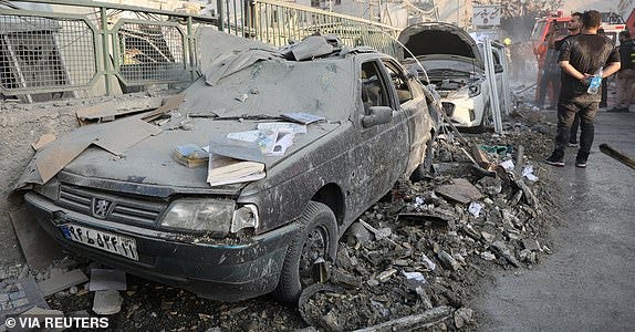 People gather near damaged vehicles in the aftermath of Israeli strikes, in Tehran, Iran, June 13, 2025. Majid Asgaripour/WANA (West Asia News Agency) via REUTERS   ATTENTION EDITORS - THIS PICTURE WAS PROVIDED BY A THIRD PARTY     TPX IMAGES OF THE DAY
