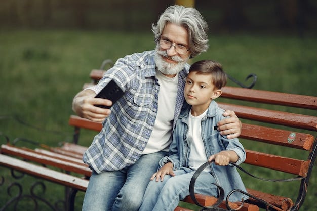 Free Photo | Boy and grandfather sitting on a bench. Family in the park.  Old man playing with grandson. Grandfather use a phone.