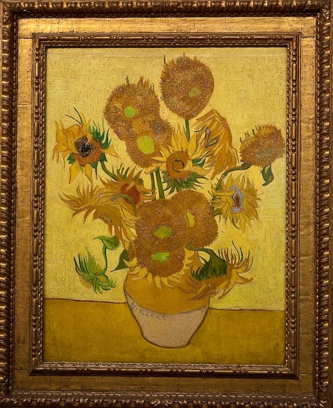 A painting of sunflowers in a gold frame

Description automatically generated