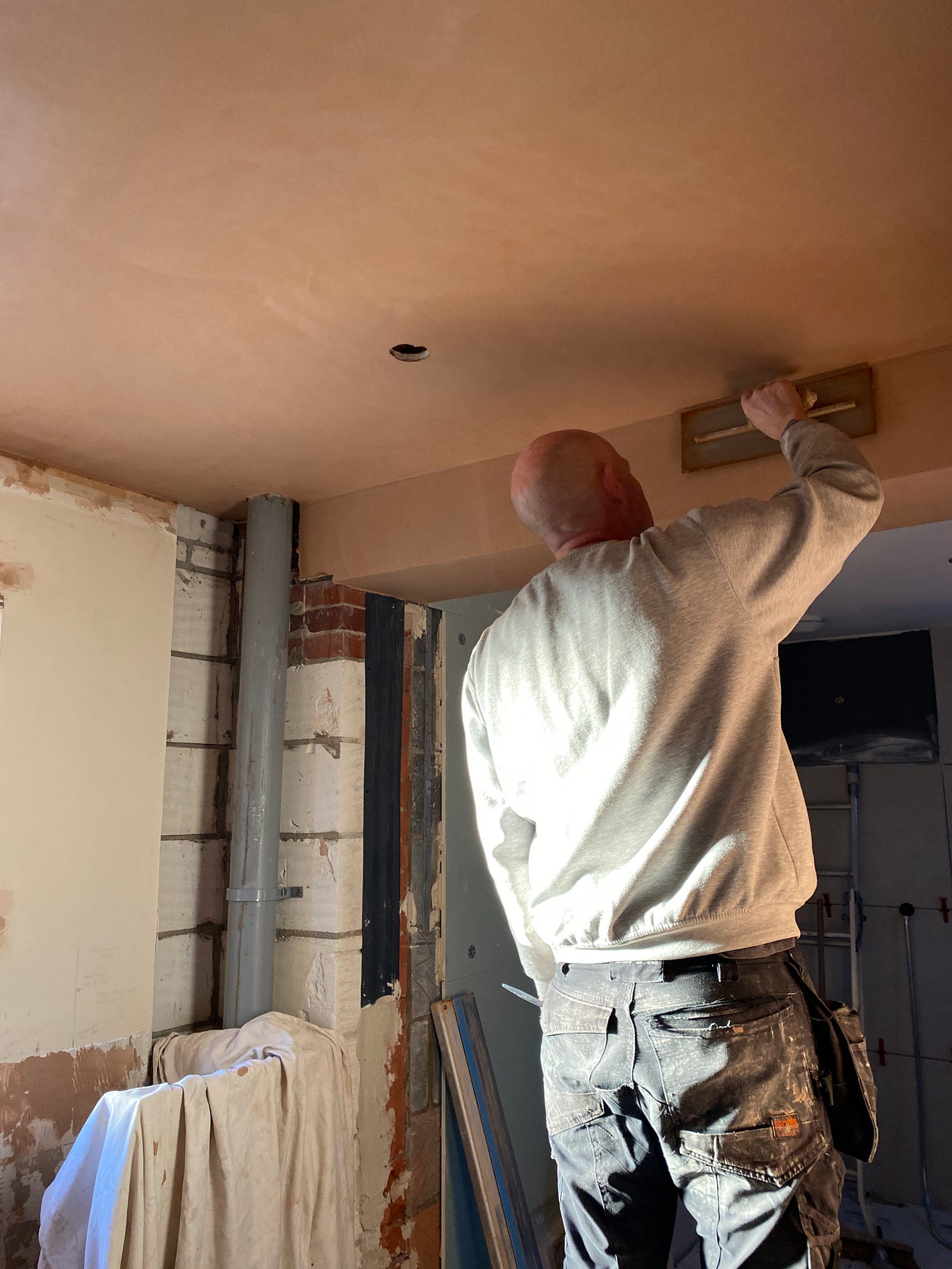 man with plastering trowel working no ceiling