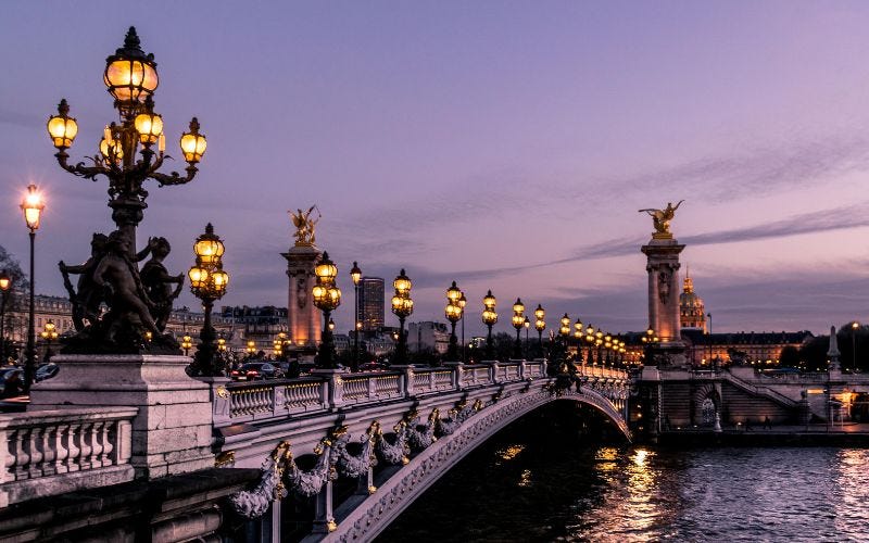 Paris bridge at night with streetlights.