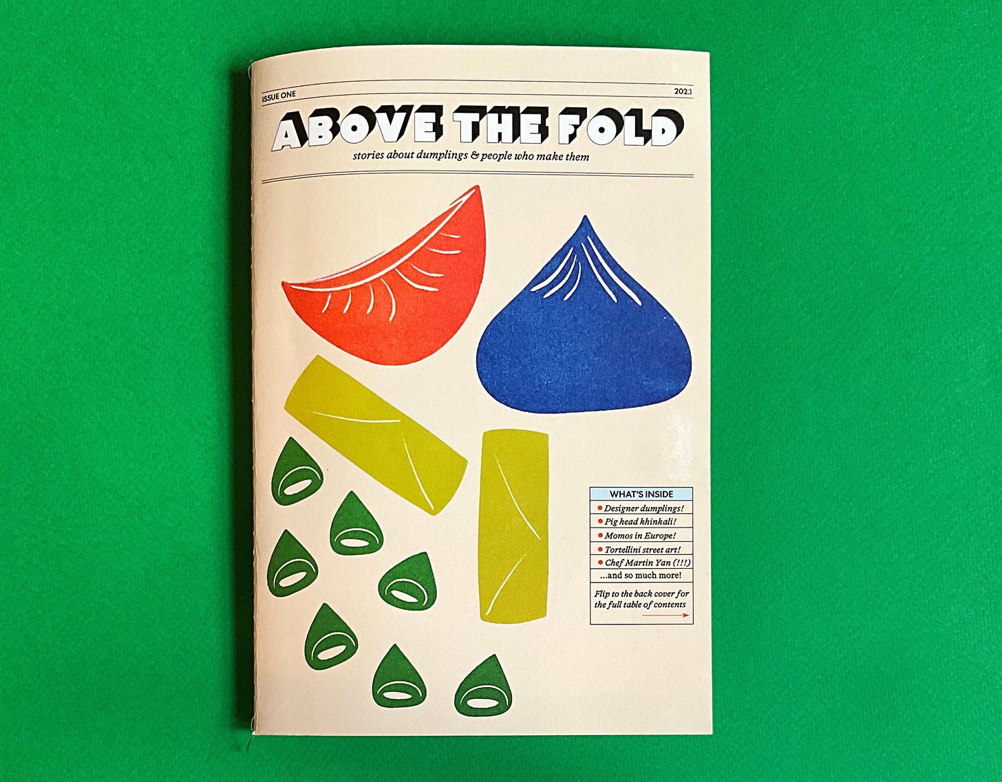 The cover of the first print issue of Above the Fold, which is covered with illustrations of dumplings 
