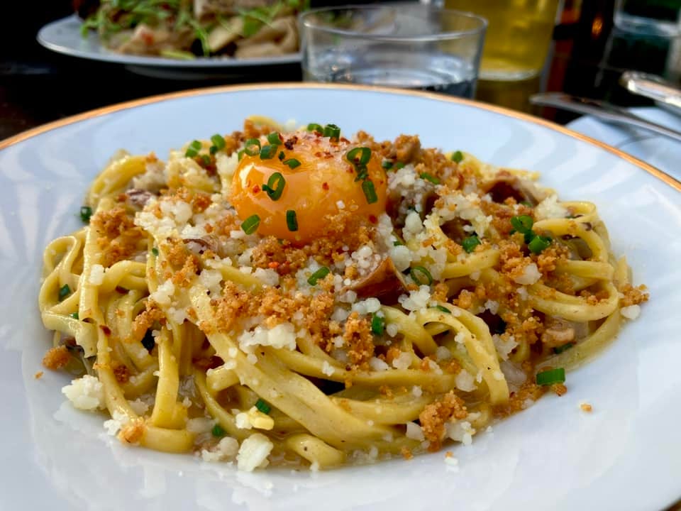 May be an image of pasta, egg yolk and poached egg