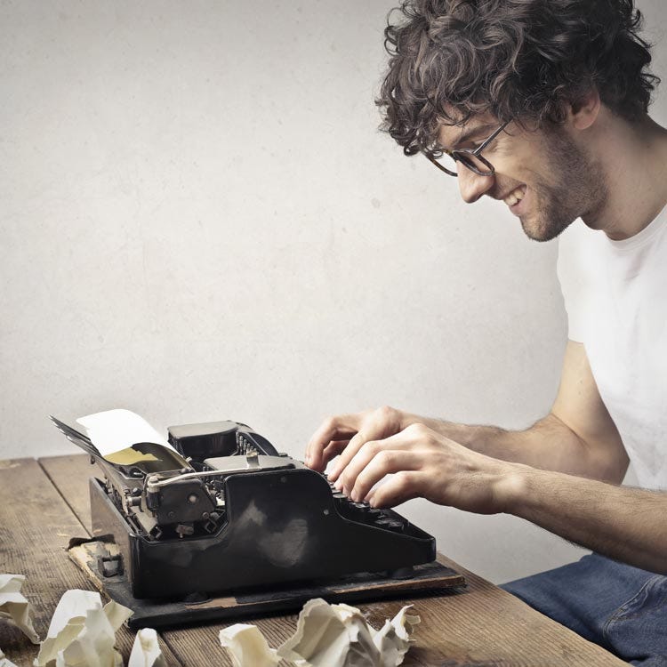 Happy writer on a typewriter going through many drafts.