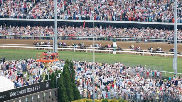 A massive crowd greets the 2024 Kentucky Derby field into the first turn.