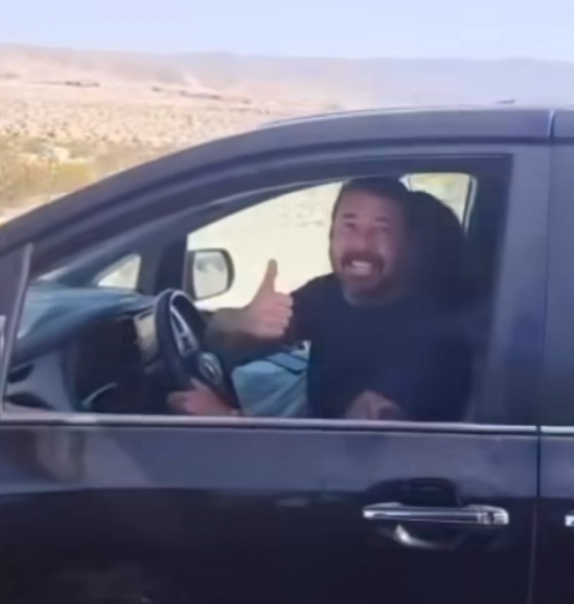 Dave Grohl giving the thumbs up from his Honda Odyssey in the desert