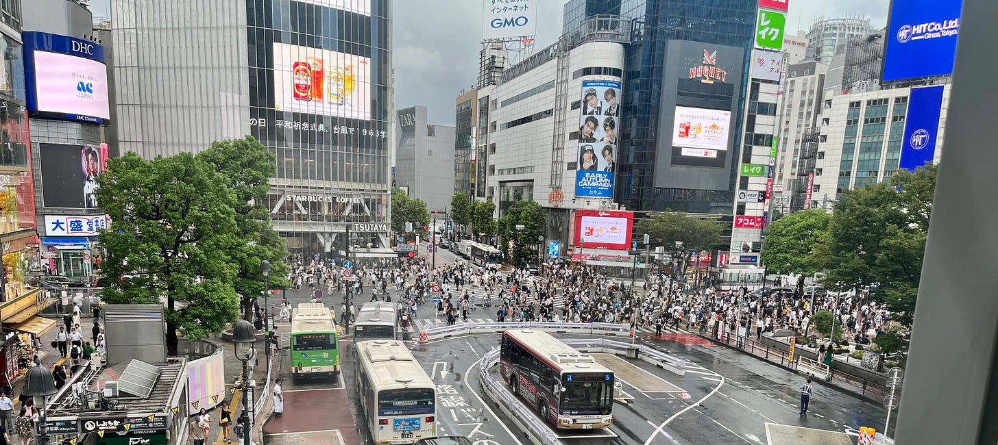 Photo of a busy crossing in Tokyo with buses and pedestrians