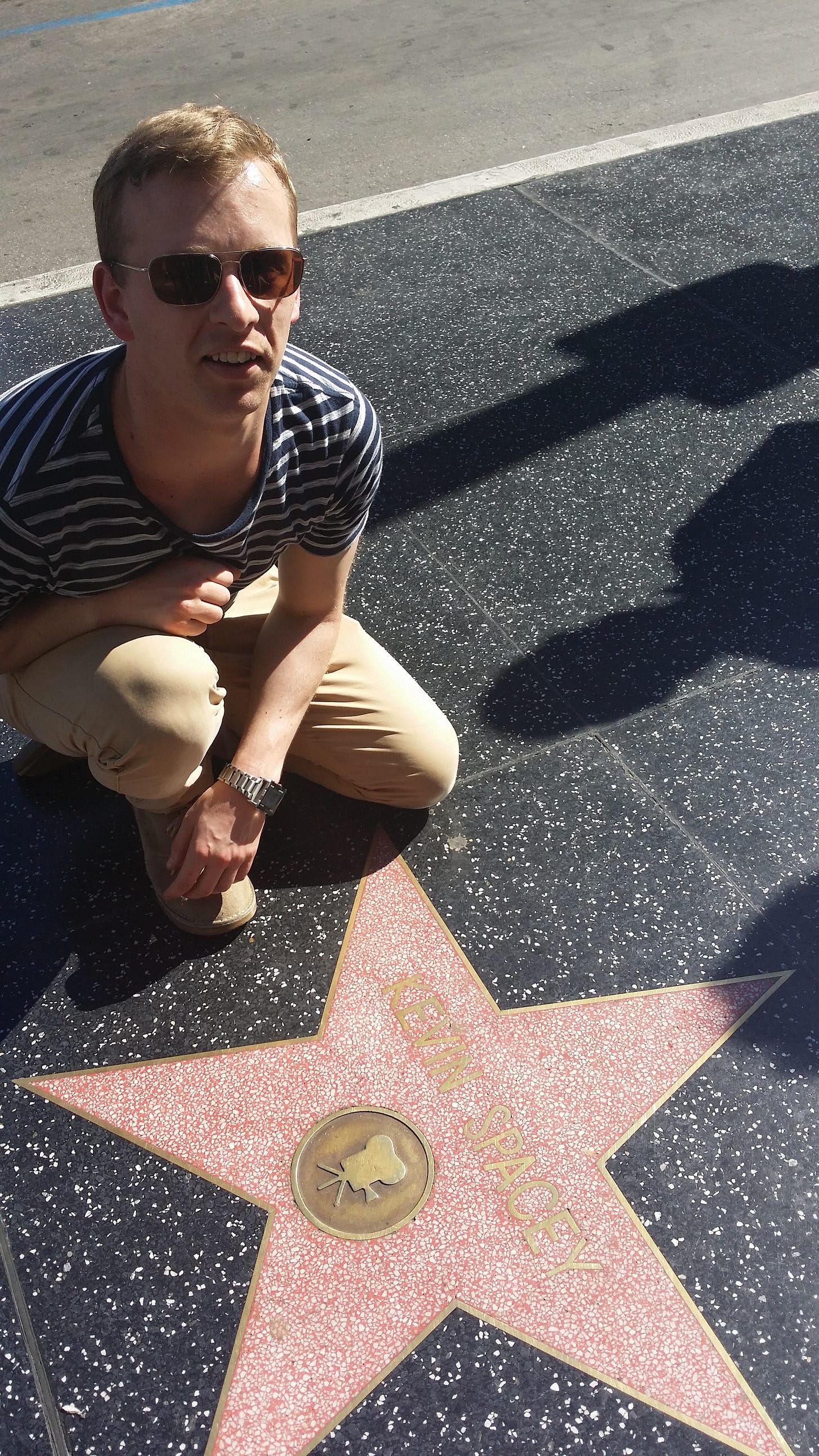 A photo of Johnny crouching by Kevin Spacey's star on the Hollywood walk of fame.