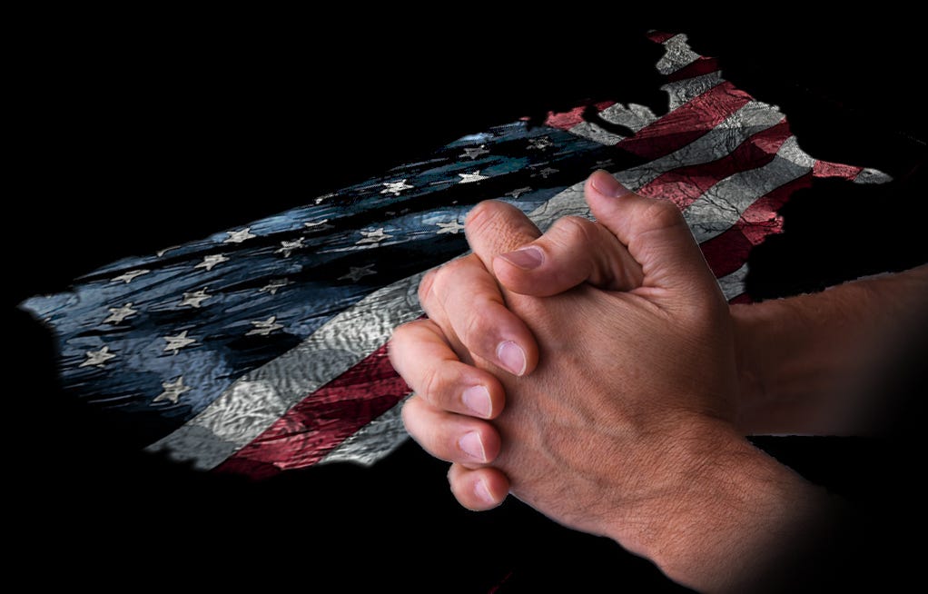 Hands clasped in prayer on top of a U.S. flag design in the shape of the contiguous states.