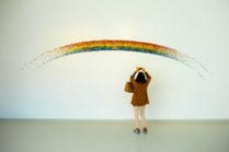 A little photographing a painted rainbow in a gallery.