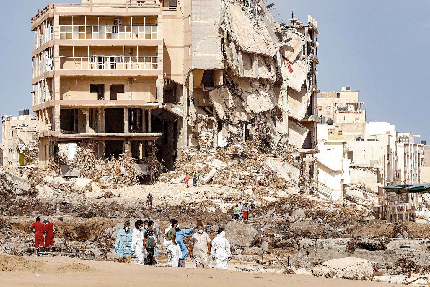 Small groups of people surveying the massive destruction Derna, Libya suffered from Storm Daniel in 2023.