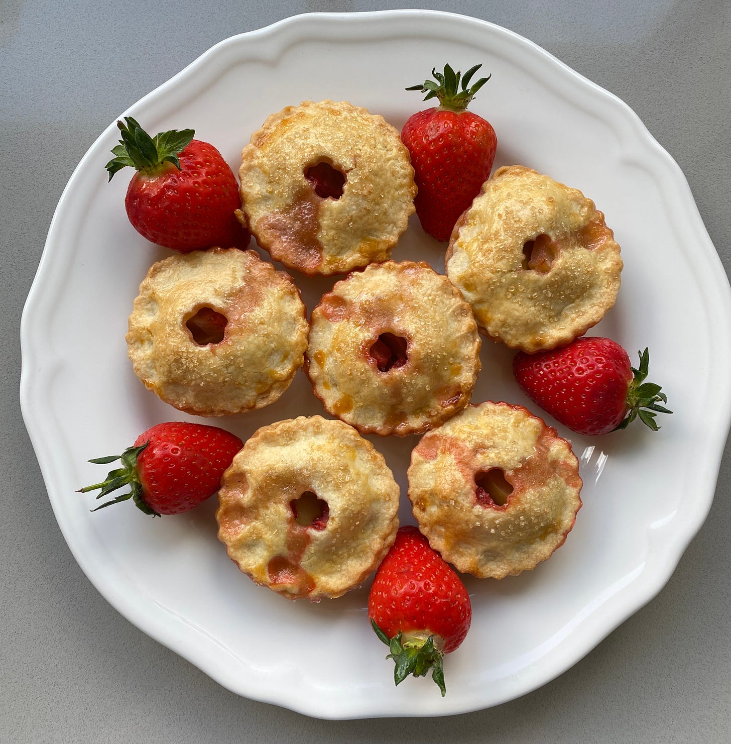 six fruit pies on a large plate.