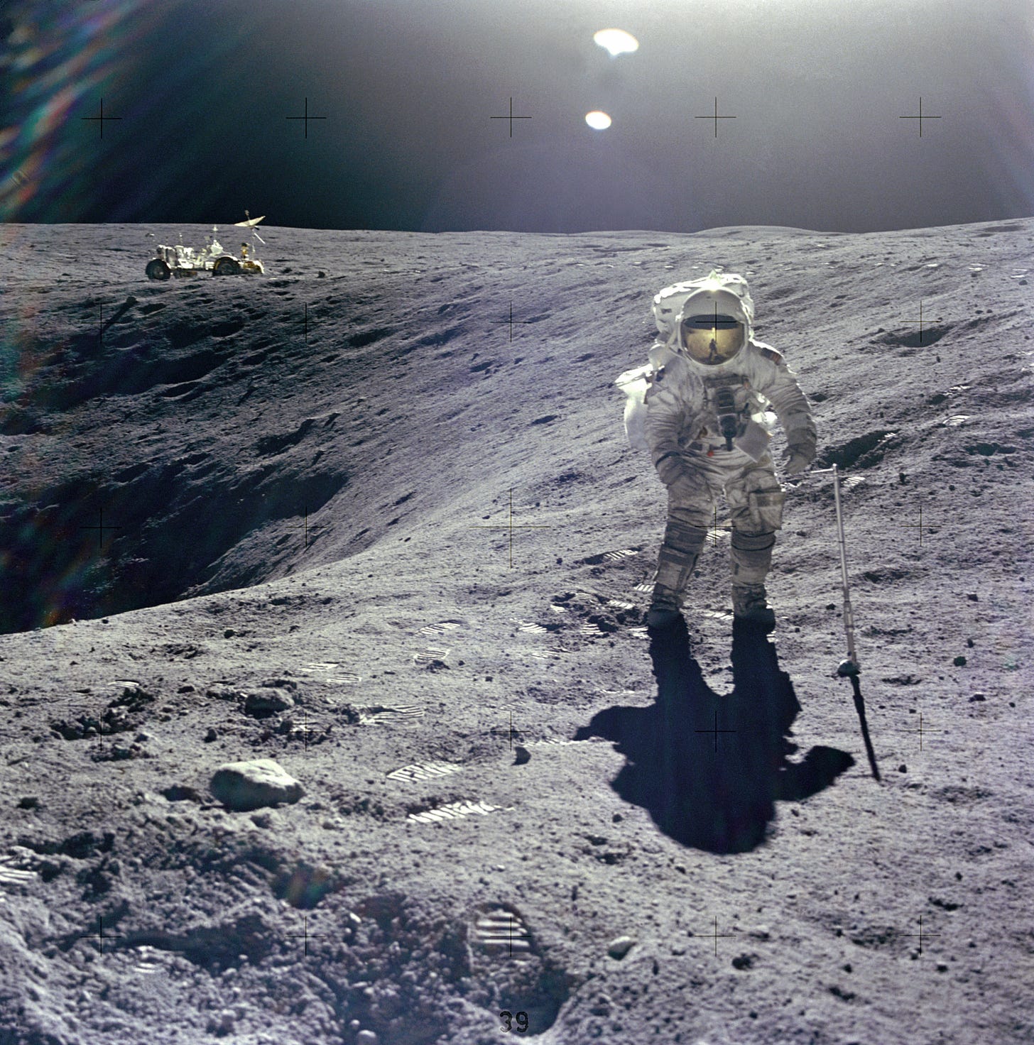 An astronaut on the lunar surface with a black abyss to his right.