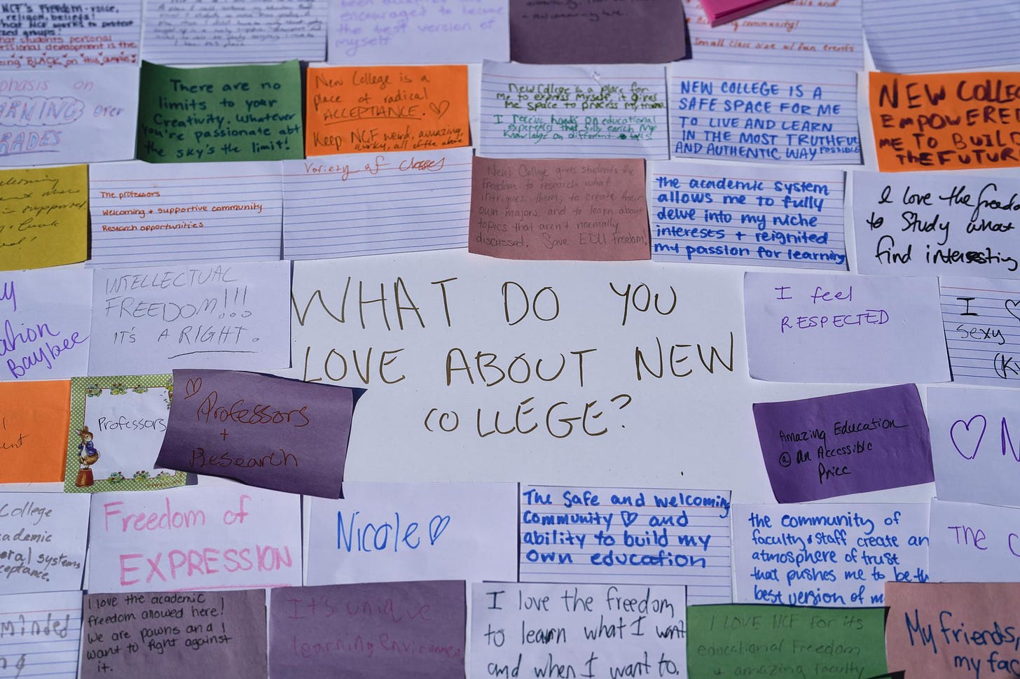Notes written by students describing what they love about New College of Florida are stuck to a poster during a protest ahead of a meeting of the school's board of trustees, Tuesday, Feb. 28, 2023, in Sarasota, Fla. Students and faculty compare the upheaval at the public honors college to a "hostile takeover" that feels even more jarring because of what the school has represented to so many students for so many years: a haven of open-mindedness and acceptance in a place of idyllic beauty, with palm-tree-lined paths along a stretch of white-sand coast. (AP Photo/Rebecca Blackwell)