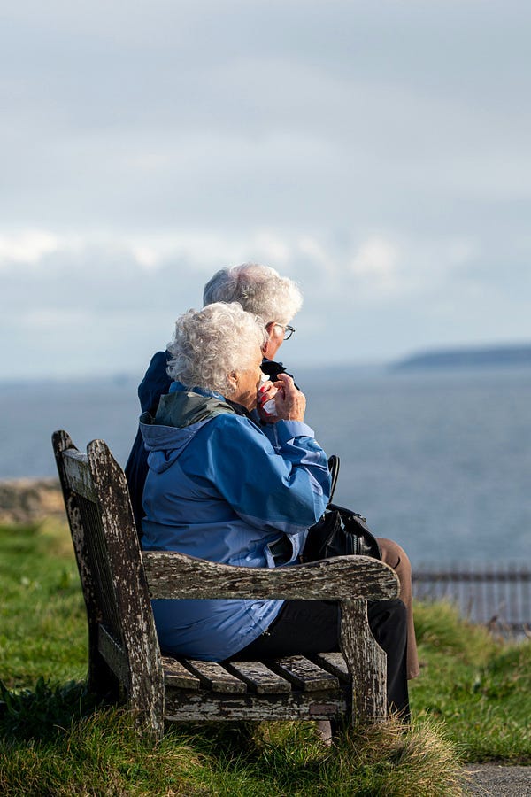 Elderly couple sitting on bench. Elderly couple sitting on bench.