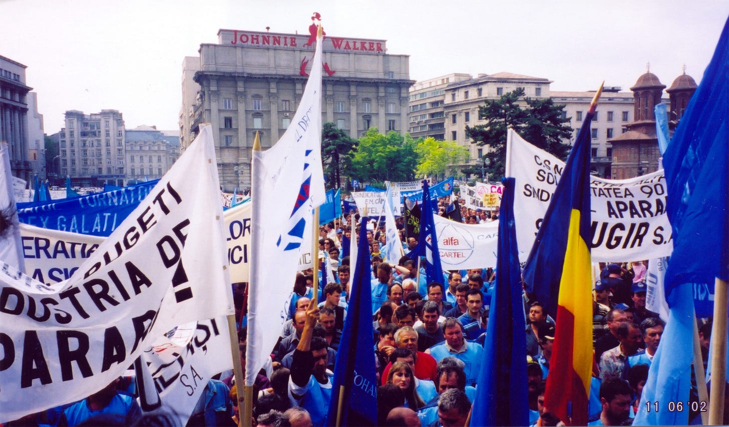 Manifestanți sindicaliști cu bannere în timpul unui protest din 2002