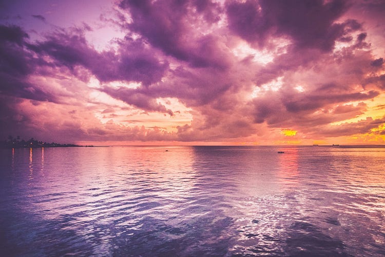 sunset over the ocean- the sky has purple and yellow hues