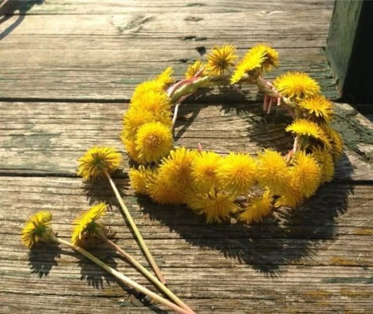 This may contain: some yellow flowers are laying on a wooden table