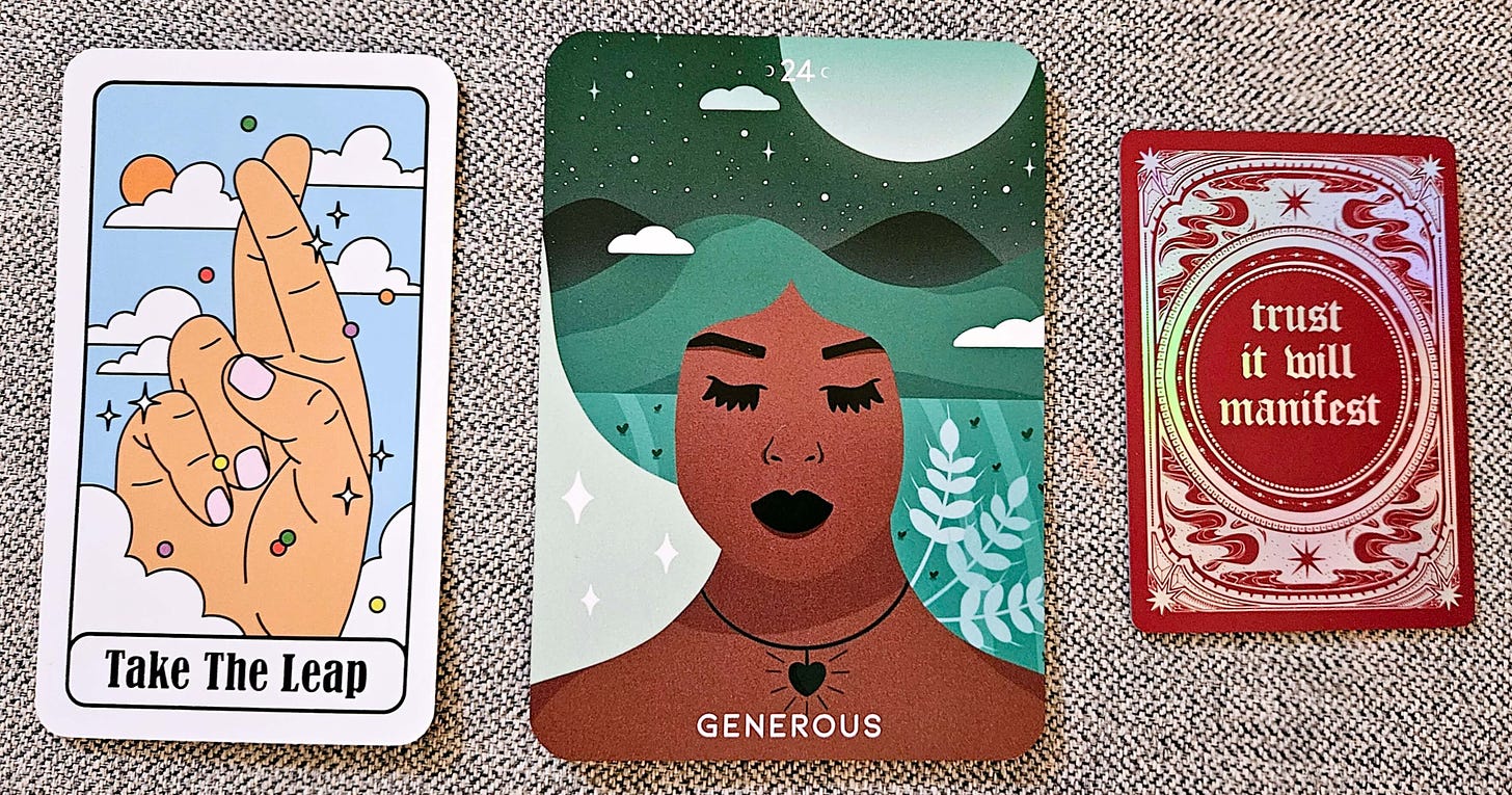 The cards revealed: the first is a hand with fingers crossed against a blue sky with clouds and sun and the words "take the leap." The second is a woman with warm brown skin wearing a heart pendant. Her eyes are closed and her hair is a green night sky with white moon and stars and leaves peeking over her shoulder. Below is the word "generous." The third card is the same deep burgundy with gold swirling design and stars and the word "trust it will manifest."