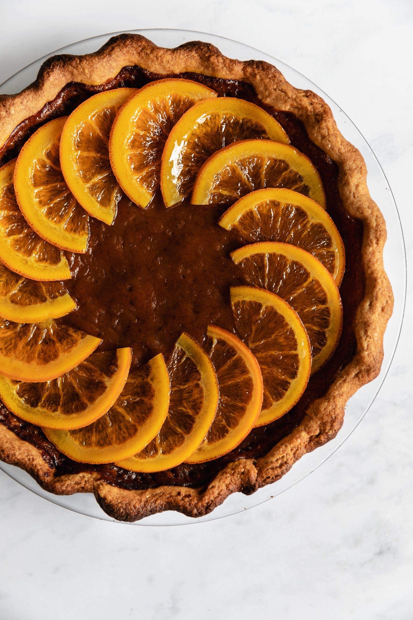 Vegan candied orange pumpkin pie on white background