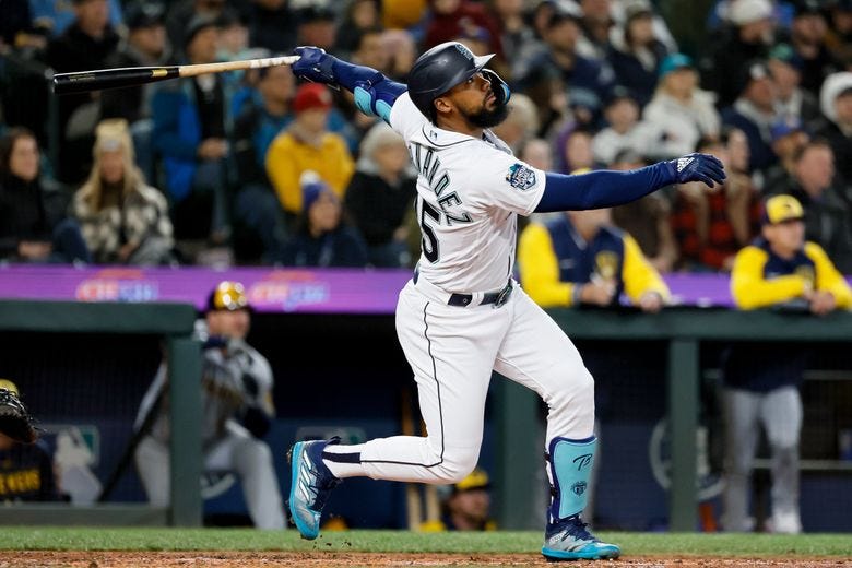 Seattle’s Teoscar Hernandez hits a sacrifice RBI to tie the game at 3-3 during the third inning against the Brewers in April. (Jennifer Buchanan / The Seattle Times)