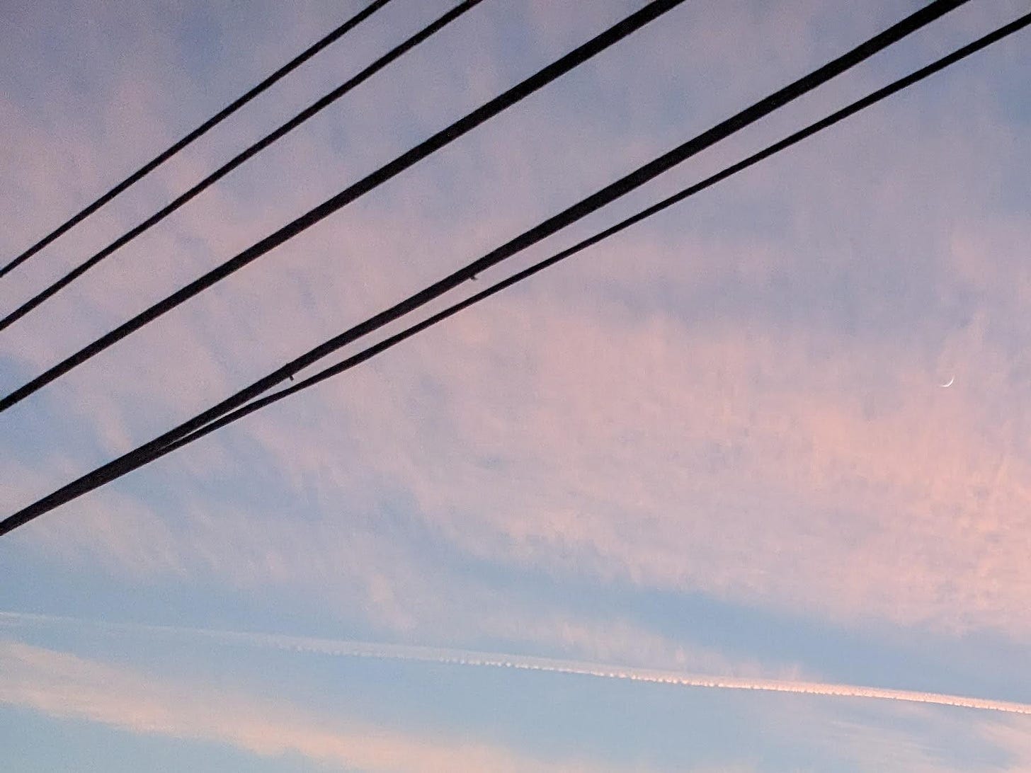 Photograph of telephone wires against a pink-and-blue clouded sunset.