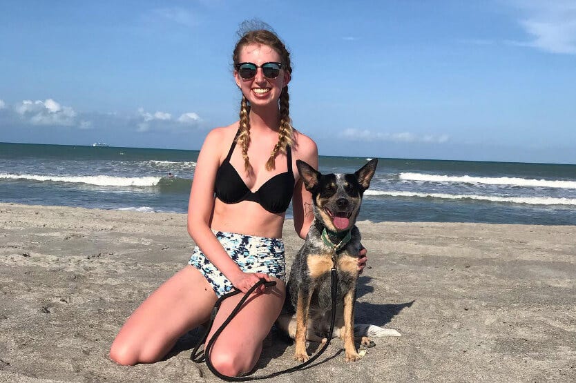 Scout the blue heeler smiling next to her owner while enjoying an afternoon on Cocoa Beach's dog-friendly beach stretch