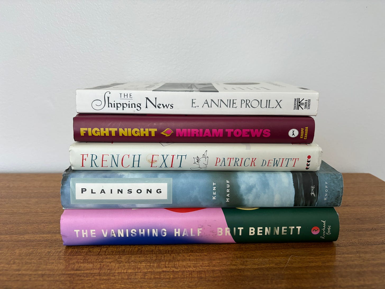 Bookstack: The Shipping News by E. Annie Proulx, Fight Night by Miriam Toews, French Exit by Patrick DeWitt, Plainsong by Kent Harry, and The Vanishing Half by Brit Bennet