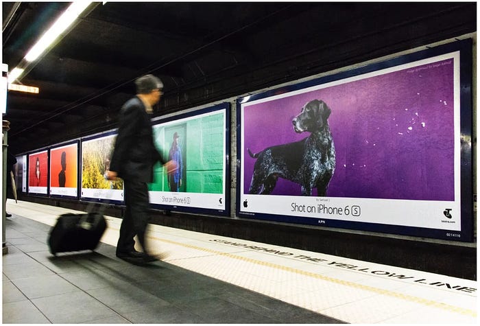 A subway station with tons of Shot on iphone ads. It’s colorful, with things like a dog with a Purple background on it, but there aren’t any pictures of phones or any details like that