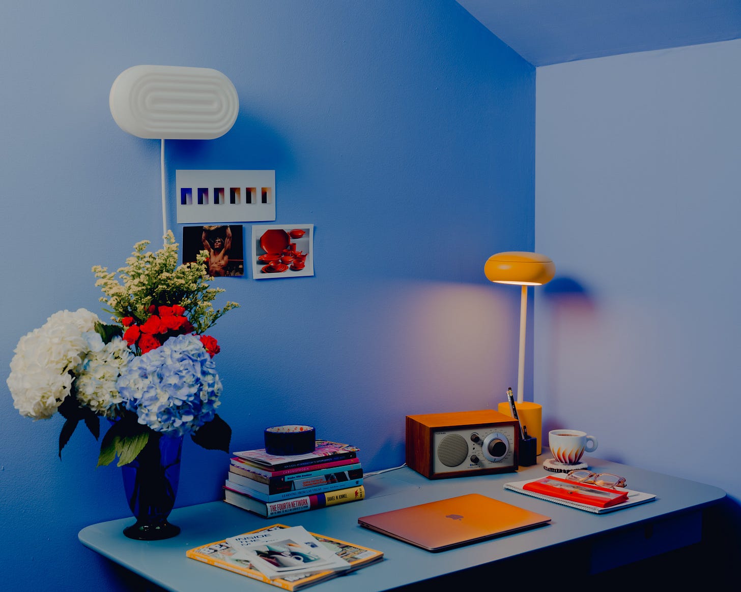 desk with bouquet of flowers laptop and lamps