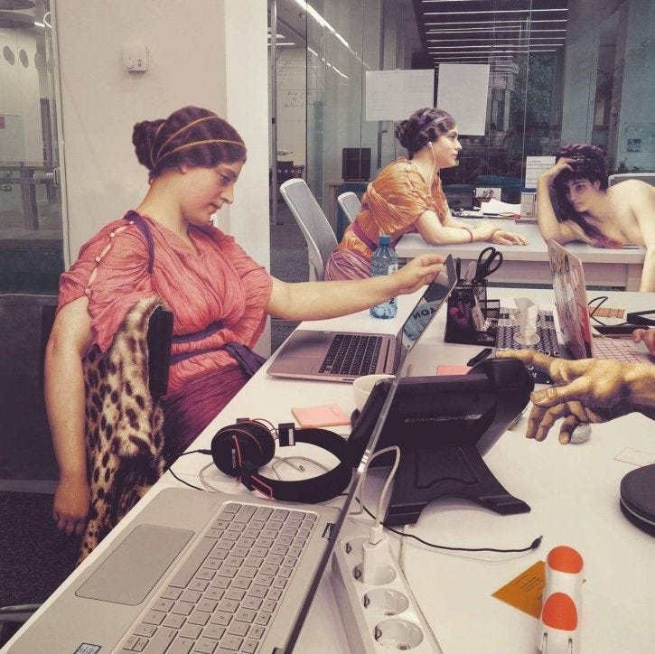 A photoshopped image of an office space populated by women from a painting in flowing robes, some in a state of semi-undress, looking bored and tired.