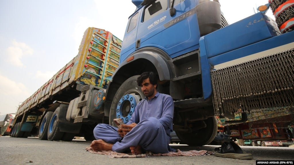A driver sits beside his parked truck, carrying goods destined for Afghanistan, waiting for the opening of the border following clashes between the security forces of Pakistan and Afghanistan, in Torkham, Pakistan, on September 7.