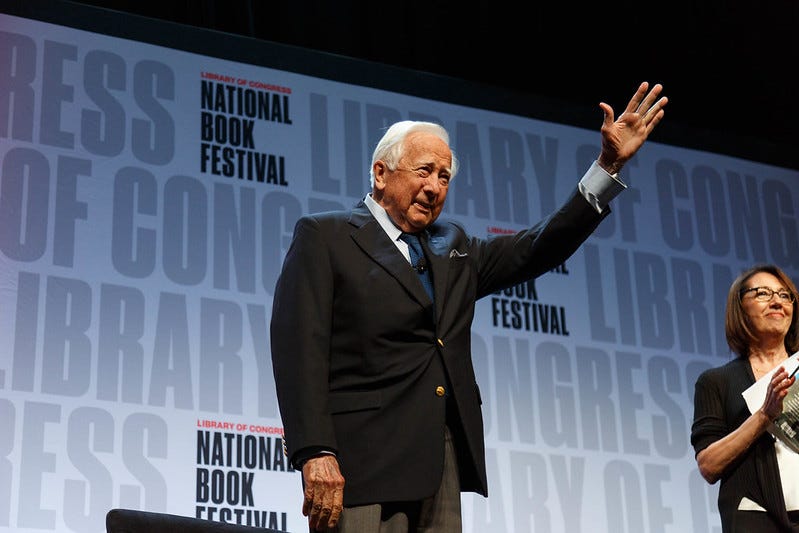 david mccullough waving to an audience before a national book festival banner